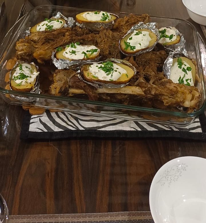 Festive table with slow-cooked meat and baked potatoes