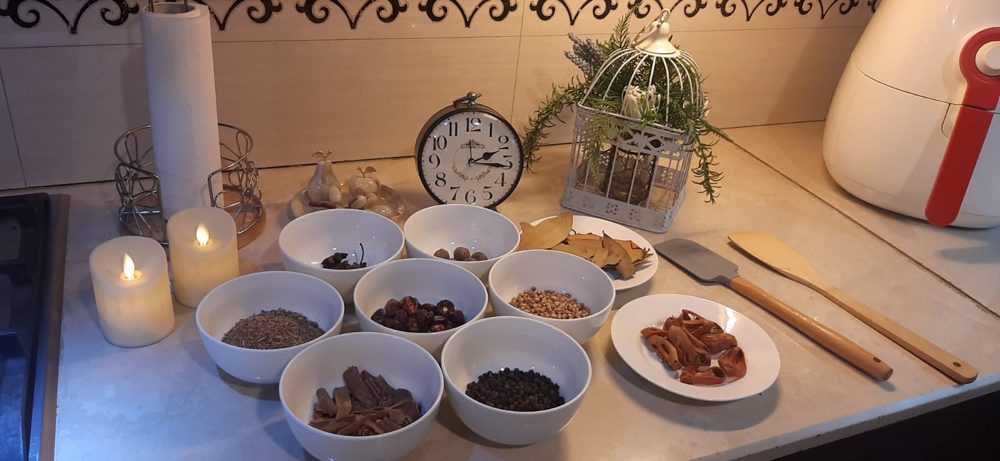 Kitchen's Aroma masala pouches with the whole spices in white bowls