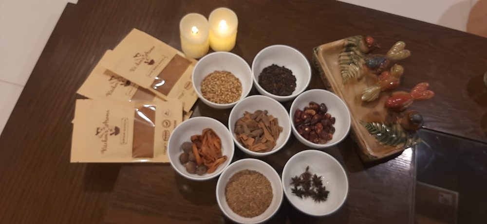 Whole spices in bowls beside masala pouches